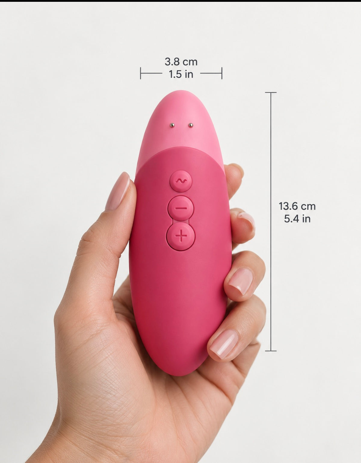 A hand holds a pink personal massager with overlaid dimension lines showing its height of 13.6 cm (5.