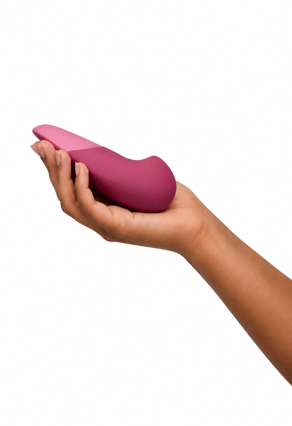 A hand holding a compact, dual-tone pink personal massager against a solid white background.