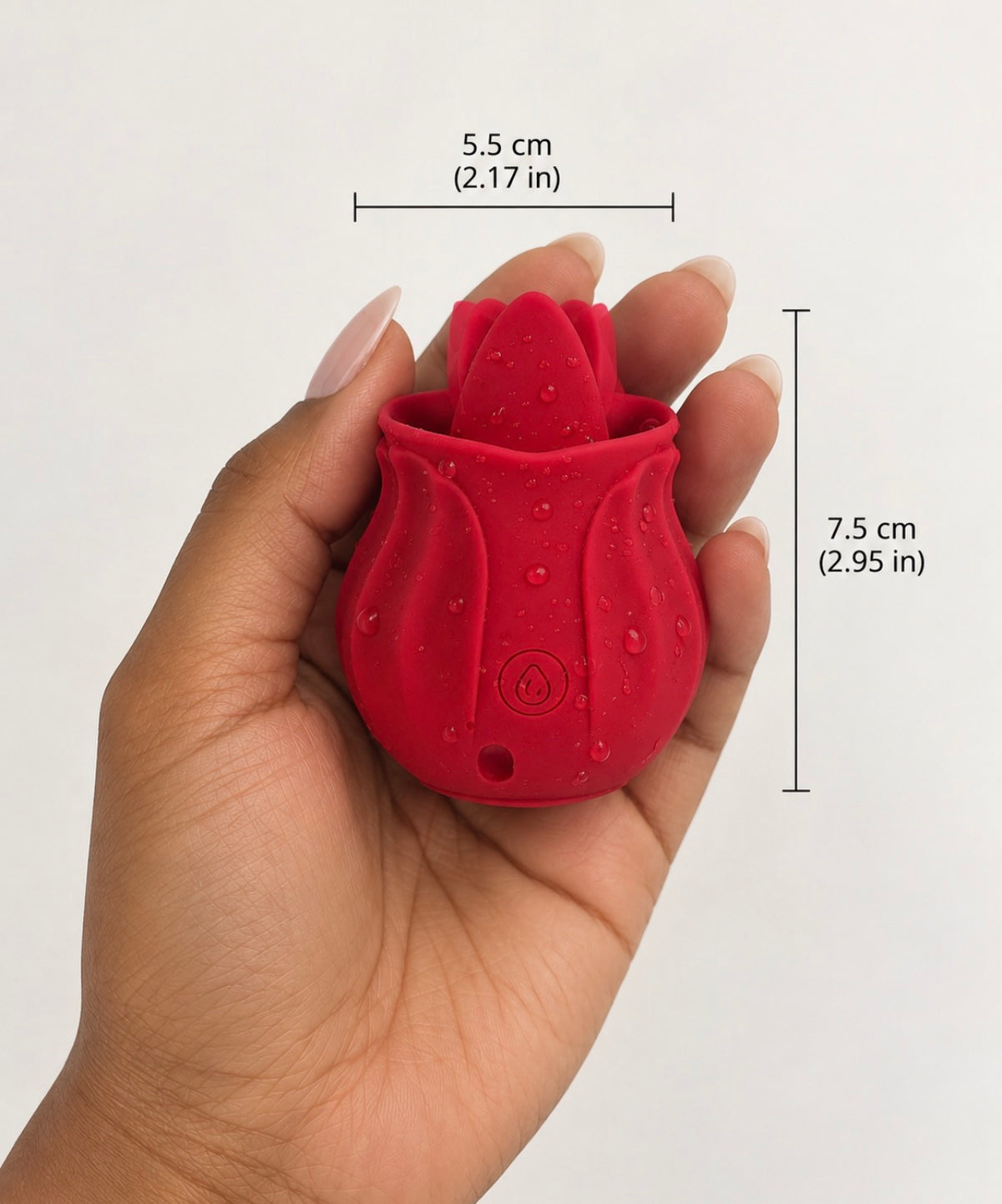 A hand holding a small red silicone flower-shaped device with overlaid dimension lines and text showing 5.5 cm width and 7.