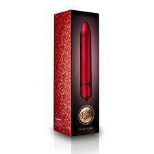 A red and black rectangular product box with ornate red patterning, featuring a glossy red cylindrical item protruding from the top and a gold circular emblem near the bottom, shown on a white background.